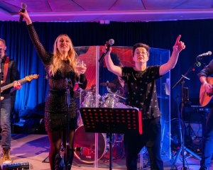 Glazbeni nastup uživo tijekom proslave 20 godina Marinoxa, s izvođačima na pozornici u svečanoj atmosferi.